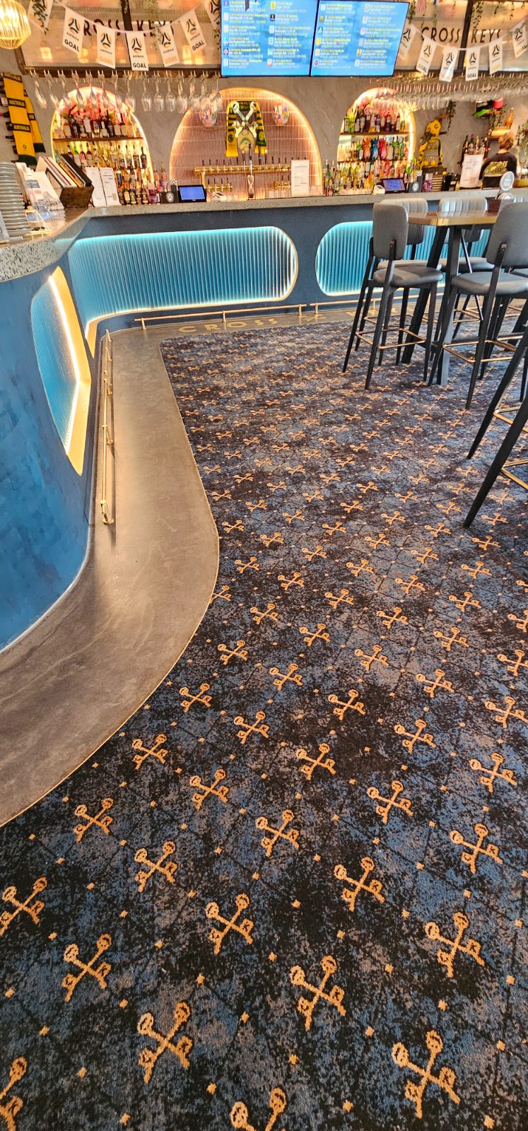 Curved bar edge with custom patterned commercial carpet laid to the bar surround