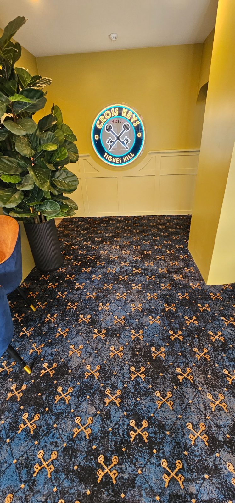Entry lounge carpet installation under the Cross Keys Hotel neon sign